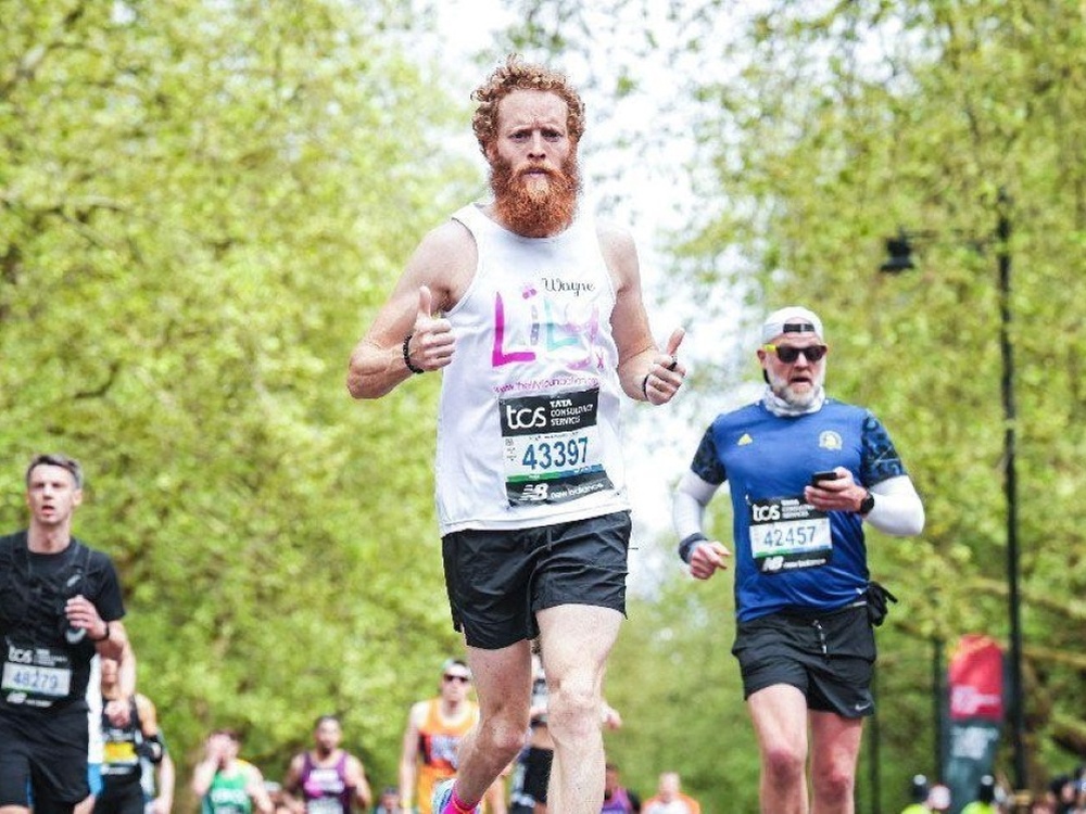 A man in a Lily vest running the London Marathon