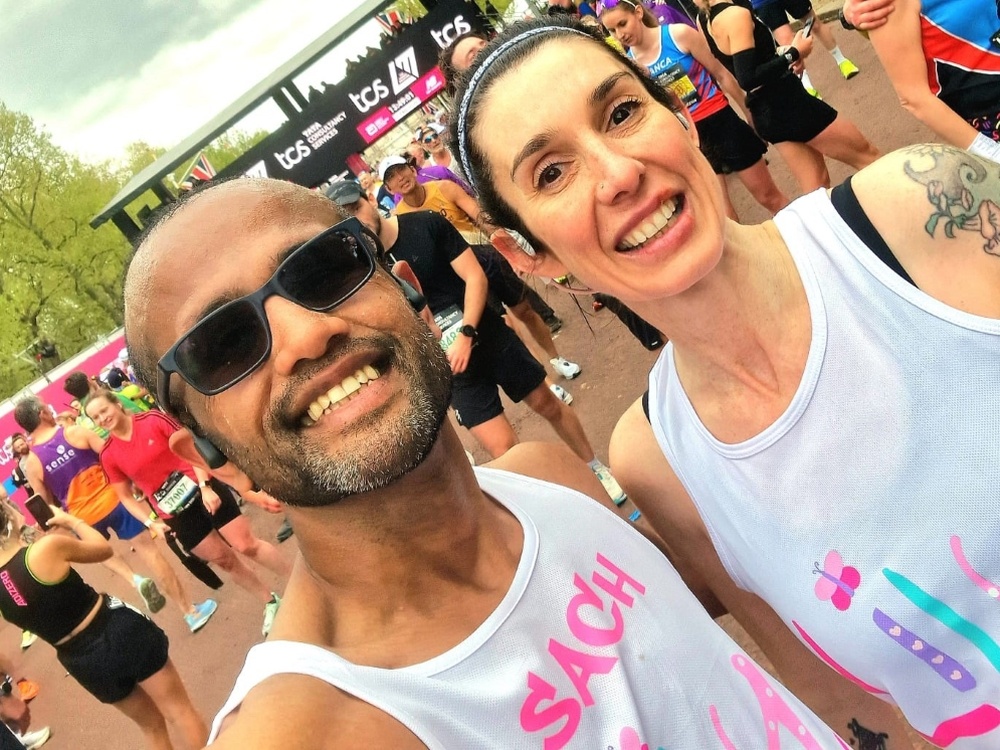 A man and a woman wearing Lily Foundation vests smiling for a selfie